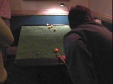 Use cue stick to hit cue ball to smallest marked area for greatest score.