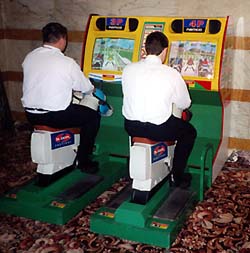Amusement arcade simulator player rocks horse in jockey motions